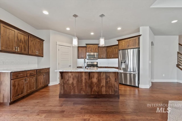 15343 Moss Creek Way, Caldwell, ID 83607 - kitchen featuring stainless steel appliances, decorative backsplash, arched walkways, baseboards, and dark wood-type flooring