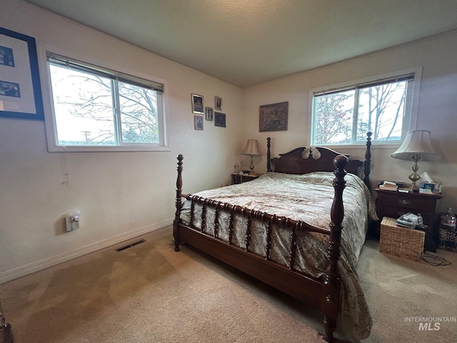 carpeted bedroom with visible vents and baseboards