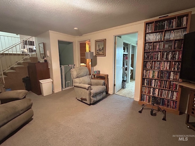 sitting room featuring a textured ceiling, carpet flooring, ornamental molding, and stairway