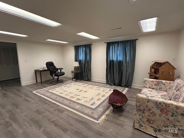 sitting room with baseboards and wood finished floors