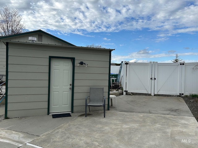 view of outbuilding featuring an outbuilding, fence, and a gate