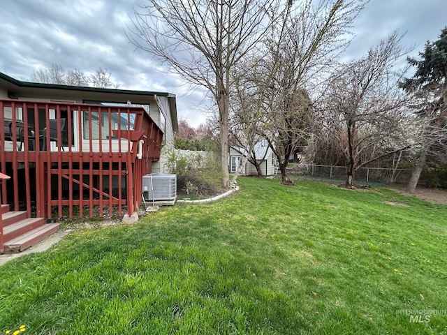 view of yard featuring stairs, central AC, a fenced backyard, a wooden deck, and an outbuilding