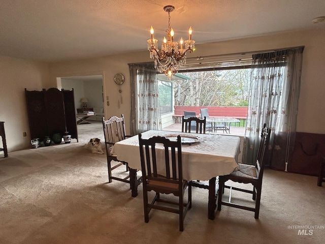 dining space with carpet flooring and a notable chandelier