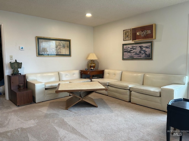 living area featuring recessed lighting, carpet, and a textured ceiling