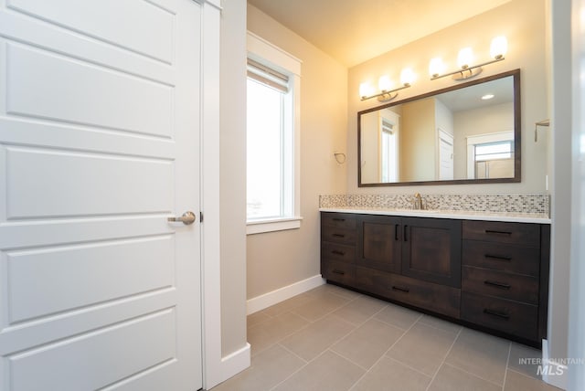 bathroom with baseboards, vanity, and tile patterned flooring