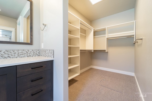 spacious closet featuring light colored carpet