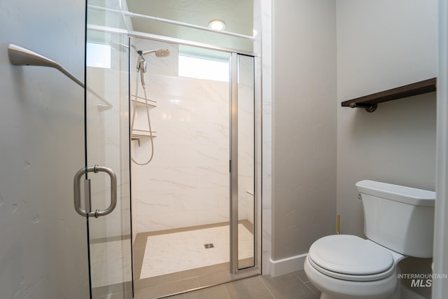 full bathroom featuring toilet, a stall shower, and tile patterned flooring