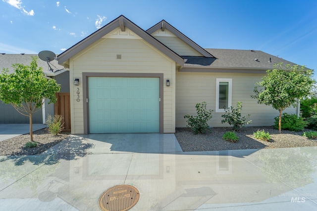 ranch-style home with a garage, driveway, and a shingled roof