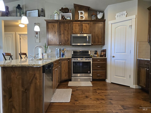 235 Meadow View Dr, Payette, ID 83661 - kitchen featuring appliances with stainless steel finishes, a peninsula, backsplash, dark wood finished floors, and vaulted ceiling
