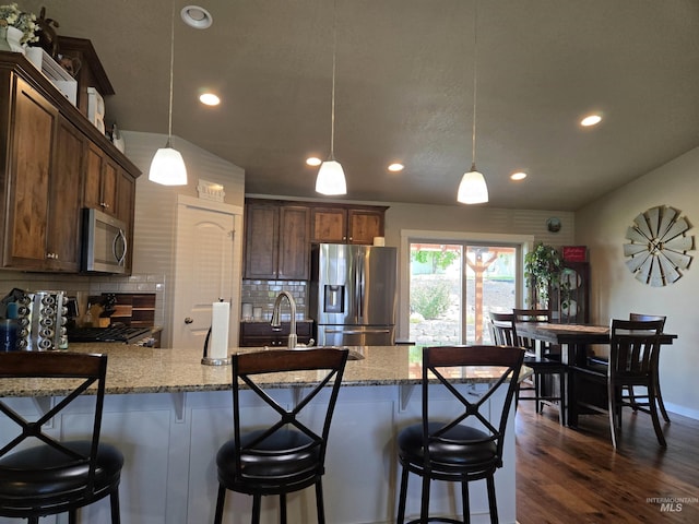 235 Meadow View Dr, Payette, ID 83661 - kitchen featuring appliances with stainless steel finishes, recessed lighting, decorative backsplash, light stone countertops, and a peninsula