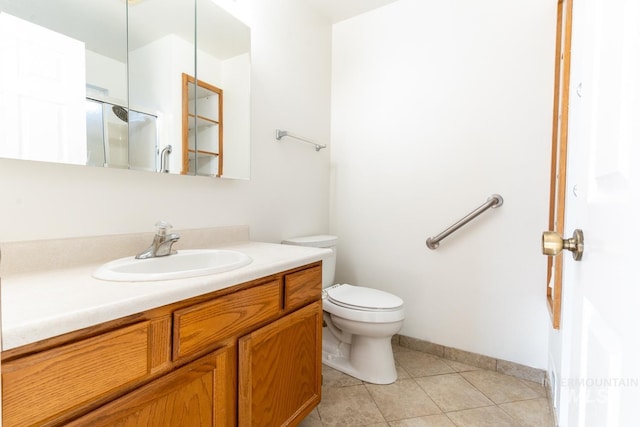 bathroom with toilet, tile patterned flooring, and vanity