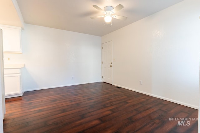 spare room with ceiling fan and dark hardwood / wood-style flooring