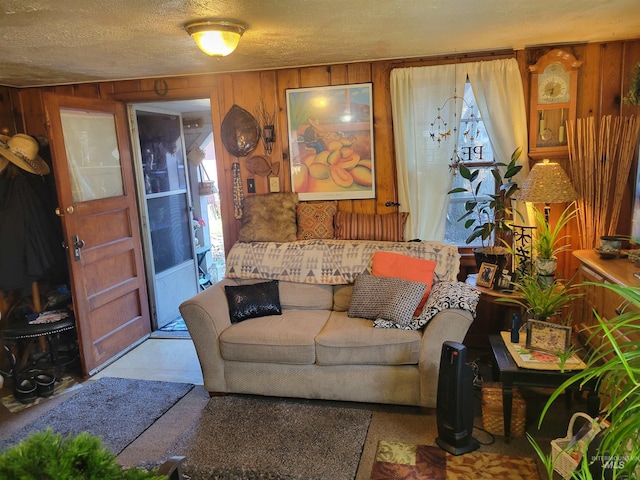 living area with wooden walls and a textured ceiling