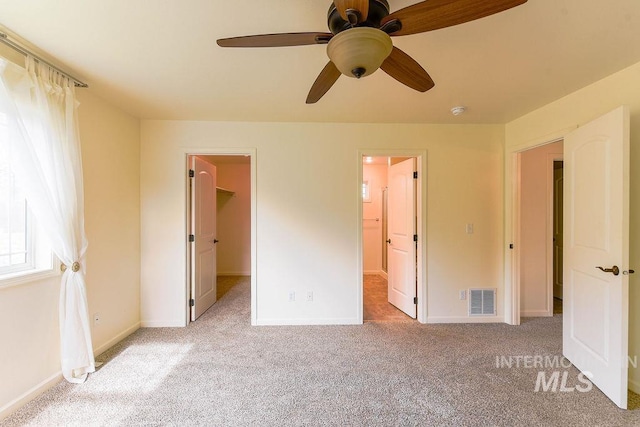 1962 E 6th St, Moscow, ID 83843 - unfurnished bedroom featuring visible vents, baseboards, a walk in closet, and carpet flooring