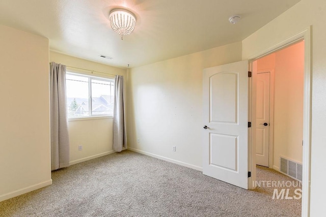 1962 E 6th St, Moscow, ID 83843 - carpeted spare room featuring baseboards, visible vents, and a notable chandelier
