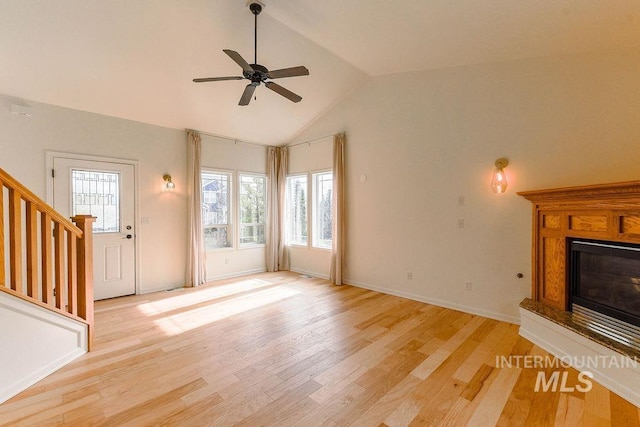 1962 E 6th St, Moscow, ID 83843 - unfurnished living room with ceiling fan, light wood finished floors, stairs, a glass covered fireplace, and lofted ceiling