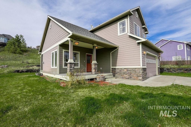 1962 E 6th St, Moscow, ID 83843 - craftsman-style home featuring driveway, stone siding, a front lawn, a porch, and a garage