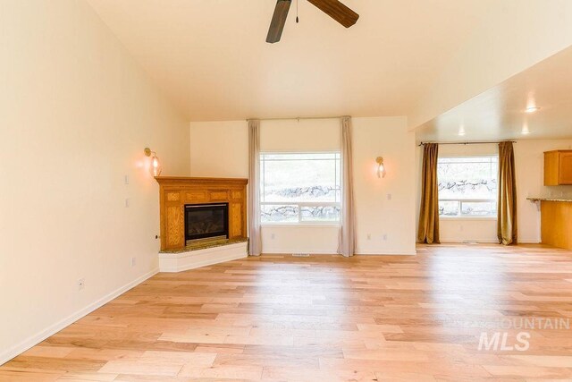 1962 E 6th St, Moscow, ID 83843 - unfurnished living room featuring a ceiling fan, light wood finished floors, baseboards, and a glass covered fireplace