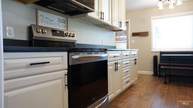 1316 Arlington Ave, Caldwell, ID 83605 - kitchen featuring wood finished floors, dark countertops, stainless steel electric range, white cabinets, and baseboards