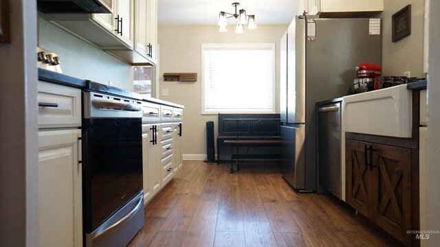 kitchen with white cabinets, extractor fan, an inviting chandelier, stainless steel dishwasher, and dark hardwood / wood-style floors