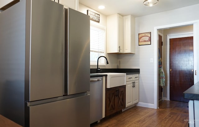 kitchen featuring sink, appliances with stainless steel finishes, dark hardwood / wood-style flooring, and white cabinets