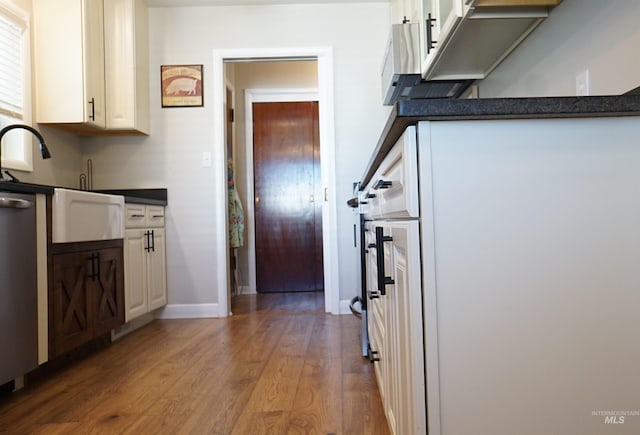 1316 Arlington Ave, Caldwell, ID 83605 - kitchen with baseboards, a sink, wood finished floors, dark countertops, and white cabinets