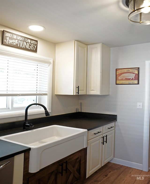 1316 Arlington Ave, Caldwell, ID 83605 - kitchen with dark countertops, white cabinetry, wood finished floors, and a sink