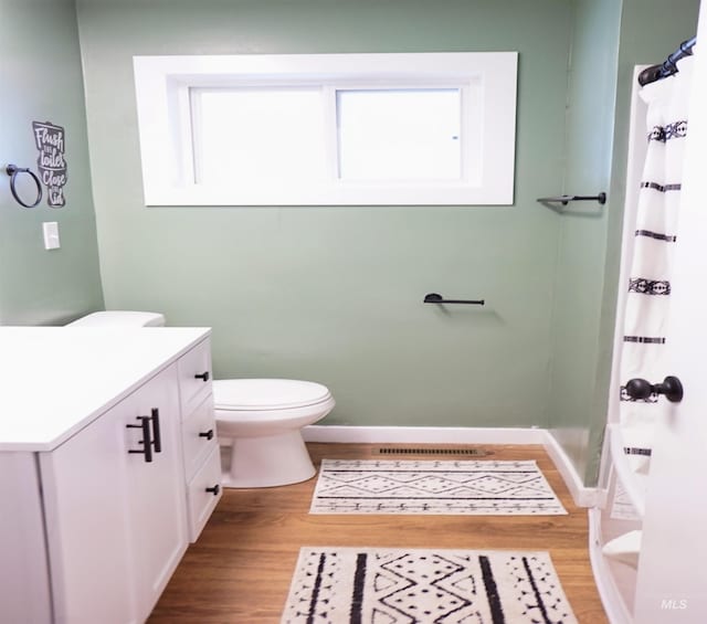 bathroom featuring toilet, hardwood / wood-style floors, vanity, and a shower with shower curtain