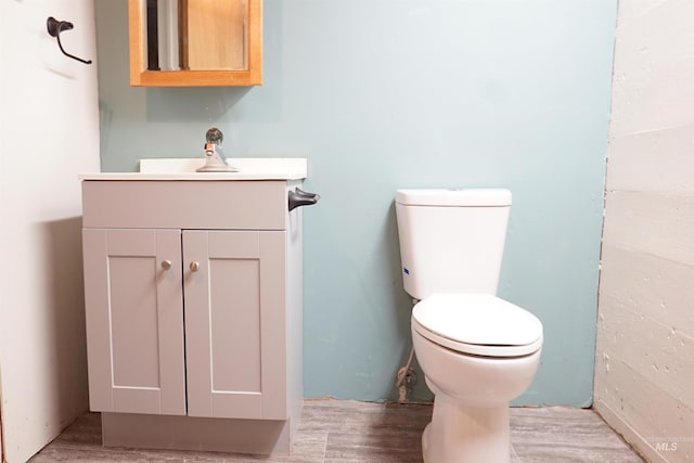 bathroom featuring vanity, wood-type flooring, and toilet