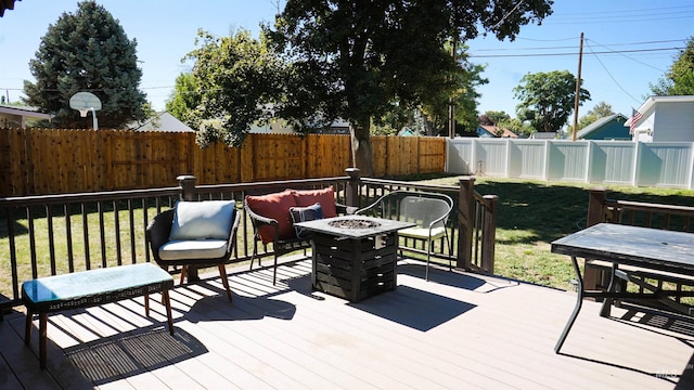 wooden terrace with a fire pit and a lawn