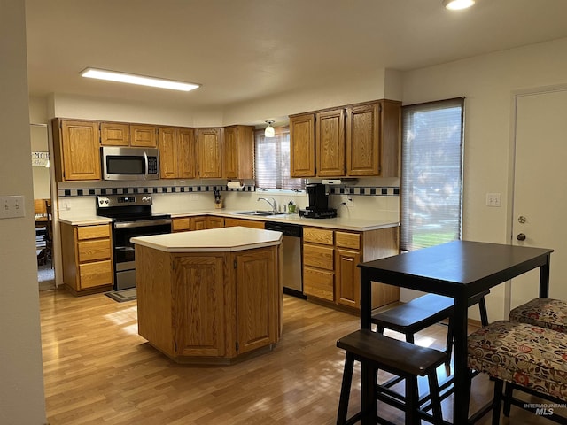 354 W Syringa Ct, Lewiston, ID 83501 - kitchen featuring appliances with stainless steel finishes, a sink, tasteful backsplash, light wood-type flooring, and light countertops