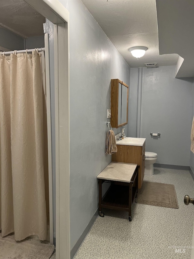 354 W Syringa Ct, Lewiston, ID 83501 - bathroom featuring vanity, toilet, baseboards, and a shower with shower curtain