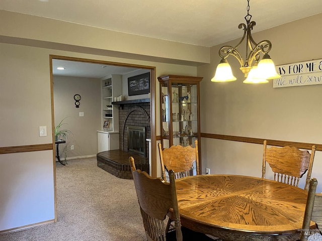354 W Syringa Ct, Lewiston, ID 83501 - carpeted dining room featuring a chandelier, a brick fireplace, built in shelves, and baseboards