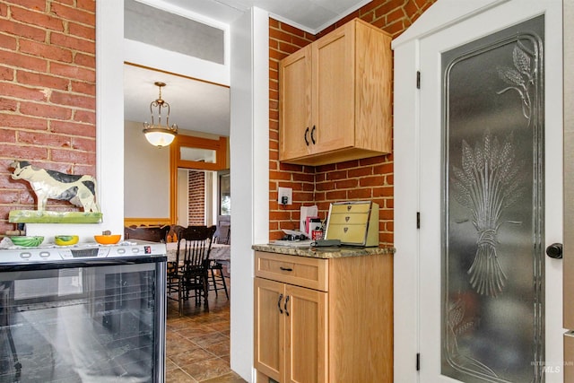 kitchen featuring light tile patterned floors, brick wall, wine cooler, and hanging light fixtures