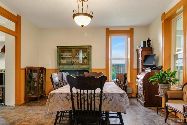 dining area featuring wainscoting and stone finish flooring