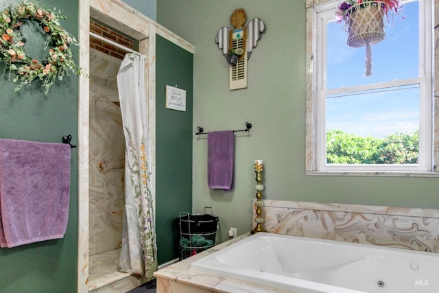 bathroom featuring a jetted tub, a shower with curtain, and plenty of natural light