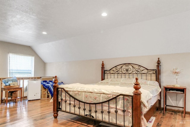 bedroom featuring recessed lighting, wood-type flooring, baseboards, and vaulted ceiling