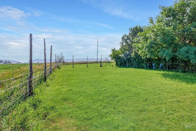 view of yard with a rural view and fence