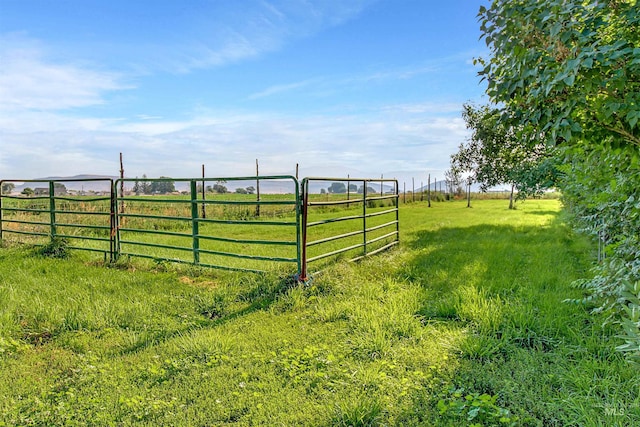 view of gate featuring a rural view and fence