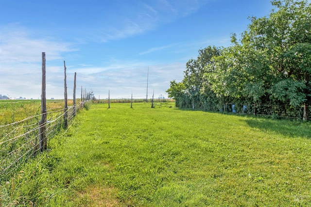 view of yard with a rural view and fence