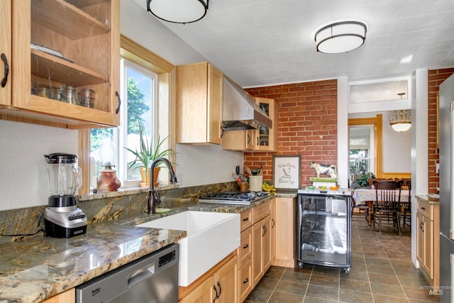 kitchen with stainless steel appliances, beverage cooler, light stone countertops, dark tile patterned flooring, and wall chimney range hood