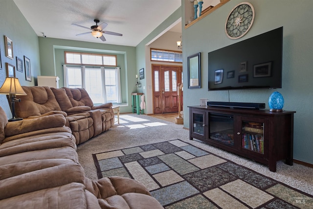 carpeted living room featuring baseboards and a ceiling fan