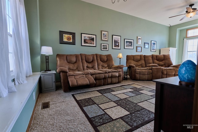 carpeted living room featuring a ceiling fan and visible vents