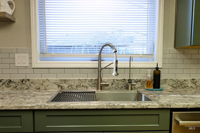 interior details featuring a sink, tasteful backsplash, dishwasher, and green cabinets