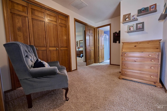 sitting room with visible vents, light colored carpet, and baseboards