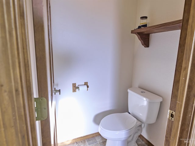 bathroom featuring toilet and baseboards