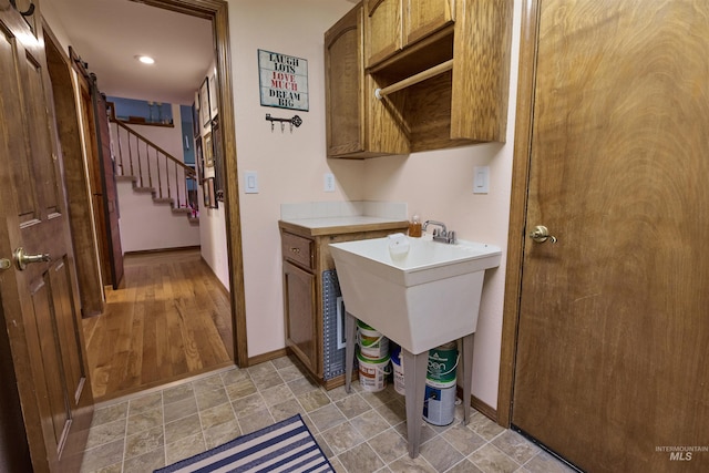 laundry area featuring a barn door and baseboards