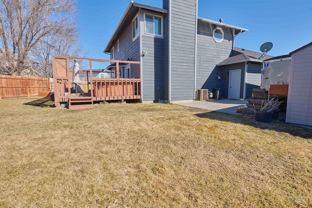 back of house with a deck, fence, a yard, cooling unit, and a chimney