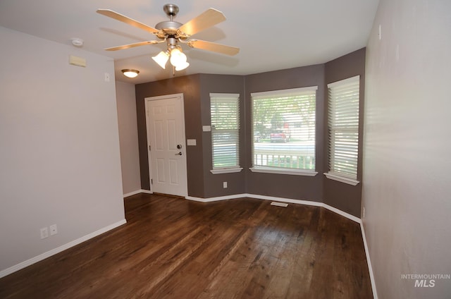 empty room featuring ceiling fan and dark wood-type flooring