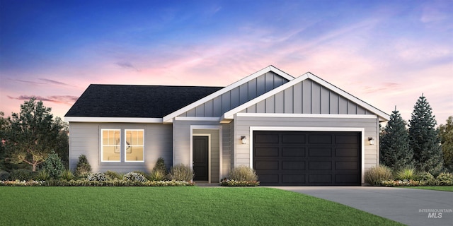 view of front of house with an attached garage, driveway, roof with shingles, a front lawn, and board and batten siding